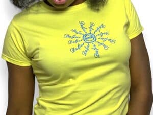 A woman wearing a yellow shirt with a blue sun on it.